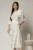 Rochie DY Fashion midi alba cu buline si funda ampla pe umar