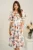 Rochie DY Fashion midi alba din satin in clos cu flori colorate si funda in talie