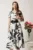 Rochie midi alba in clos cu imprimeuri florale negre si curea in talie