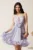 Rochie scurta lila din voal in clos cu volanase si floare maxi pe talie