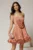 Rochie scurta roz coniac din voal in clos cu volanase si floare maxi pe talie